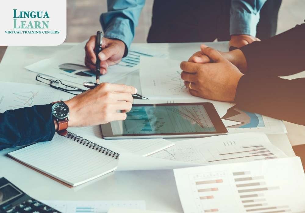 Hands of three people discussing data over a tablet and papers with charts