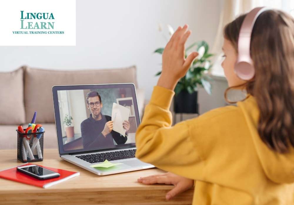 Student wearing headphones waving at a teacher on a laptop during an online class
